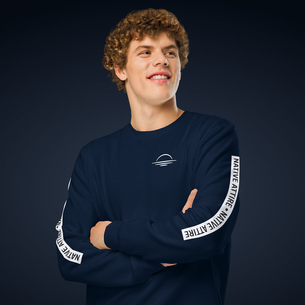 A man wearing a navy organic cotton men's jumper on a blue background.