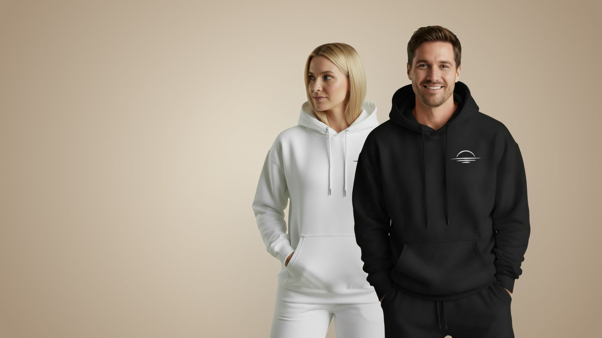 Two models showing a men's organic cotton hoodie in black and women's organic jumper in white.