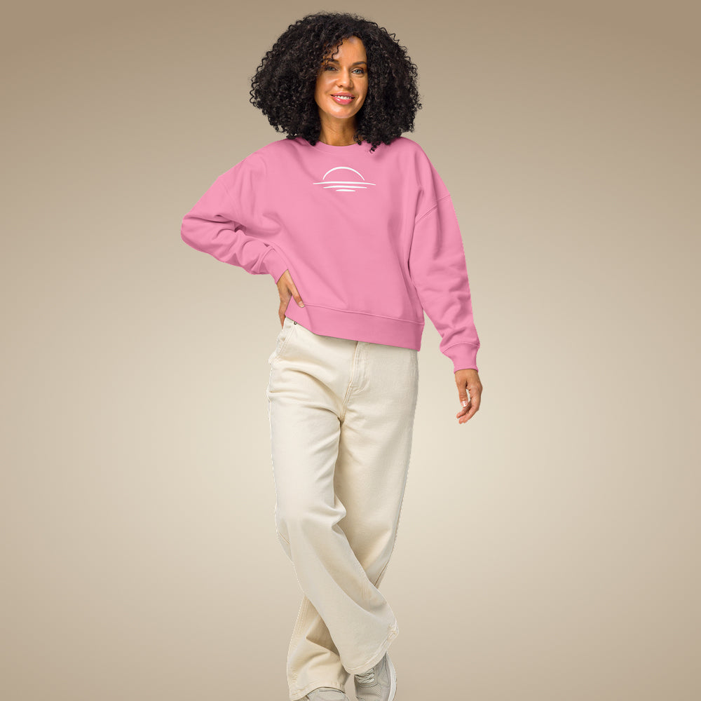 A woman stood posed wearing an organic vegan sweatshirt in pink