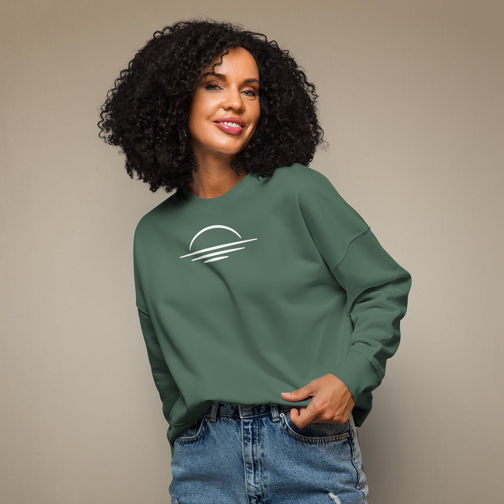 Women's organic sweatshirt made from 100% organic cotton in khaki green worn on a female model against a beige background.