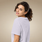 Woman wearing a light lavender organic cotton t-shirt against a beige background